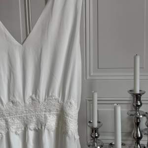 Fin vit klänning med spets runt midjan, perfekt inför sommaren, studenten eller midsommarfirandet. Lätt och luftig i väldigt fint skick. ☀️