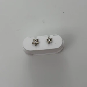 Örhängen - Jättefina silvriga örhängen i stjärnform med en fin sten i mitten!! Rengör alla smycken innan jag skickar dem!! 