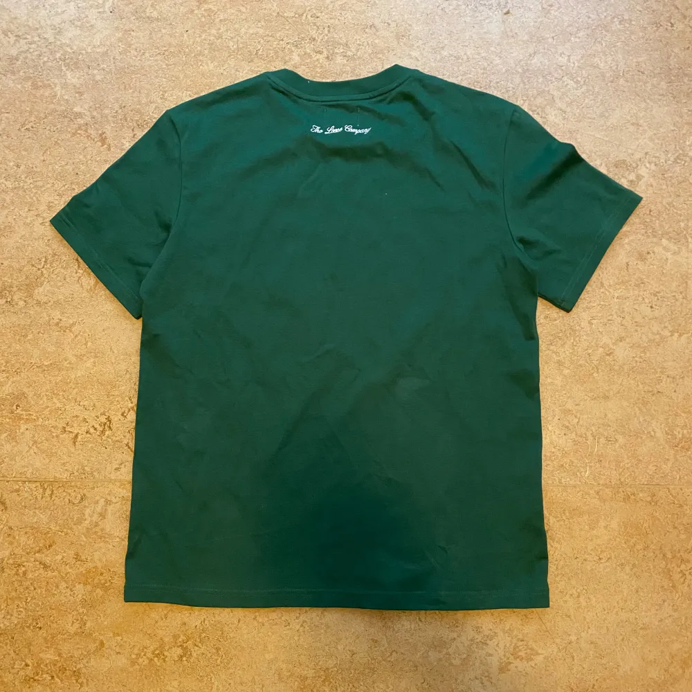 Mörk grön t shirt med tryck storlek M, aldrig använd då den är för liten. T-shirts.