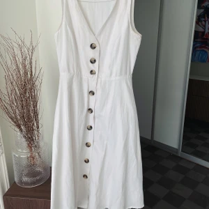 Vit sommarklänning med knappar  - Jättefin sommarklänning med knappar, midi längd. Storlek 34. Fint skick