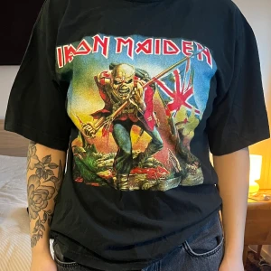 IRON MAIDEN T-shirt - Iron Maiden T-Shirt Storlek ca S/M Obs. Ett litet hål vid vänster sida längre ner 