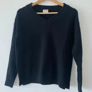 Gullig, svart V-ringad tunnstickad tröja från Vila med slits på sidorna