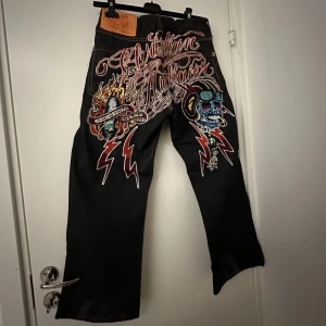 Christian Audigier Ed Hardy Jeans - Coladte jeans från Christian Audigier,EdHardy som jag inte använder mycket,användes bara några gånger, jeansen är just nu sydda för att passa 36, stygnen är enkla att ta ut om man vill ha dem större (jag kan göra det inna jag skickar