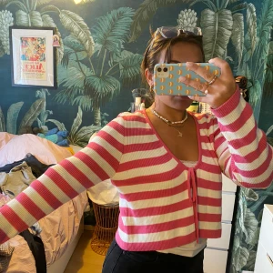 Randig kofta - Randig kofta som man knyter som rosett i fram. Rosa och vitrandig. Så söt att ha över en vit Bandau eller liknande!  Använd fåtal gånger. Large men ganska liten i storleken 