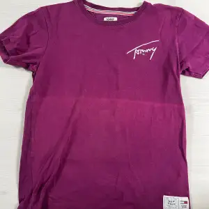 Lila Tommy Hilfiger T-shirt, storlek S. Mycket fint skick då den knappt blivit använd, däremot har där blivit ett ljust typ av streck när den blev tvättad en gång. Därav priset. Som ny kosta den 499 ungefär