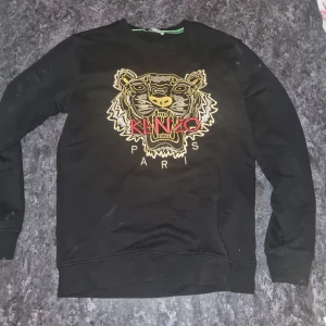 Kenzo tröja - Kenzo tröja för endast 300 spänn.  Haft på mig den ett par gånger under sommaren förra året men ser ut som ny.  Det enda dåliga med tröjan är att ett par stygn har lossnat på O:et men som du ser så ser den helt ny ut om man inte märker till👍
