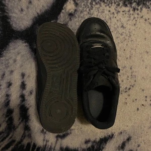 Nike Air force 1 black - Säljer mina air force ones, de är creasade eftersom storleken är för stor. Annars ser de väldigt bra ut irl och är i bra skick. Används aldrig och har inte använts på cirka 1 år.