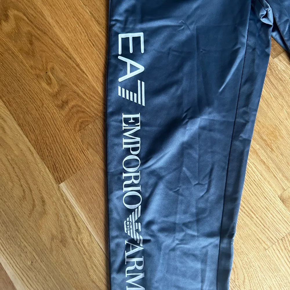 Gråa mjukisbyxor från emporia Armani. Med tryck längst benen. Liten i storlek.. Jeans & Byxor.