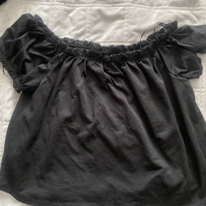 Topp - En svart of shoulder topp från Gina tricot. Den är i storlek M och har endast använts en gång, den är i väldigt bra skick.