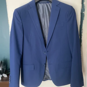 Blå Dressman kostym - Säljer min blåa Dressman kostym i storlek 46S slim fit och byxorna i storlek 32-32. Endast använda en gång och inga defekter. Nypris 2499kr Är öppen för att sälja kostymdelarna separat. Bara att skriva vid frågor och funderingar! 