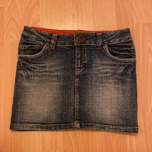 Jeans kjol - I fint skicka, köpt secondhand. Inga defekter och stretchigt tyg.  Midjemått: 37 cm Längd: 33 cm 