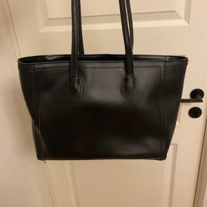 Handväska- svart - En svart väska som går att användas till tex skolan eller vanligtvis, kommer ej till användning längre och därför säljs den, brukade användas som skolväska! Kan fraktas och mötas upp :)