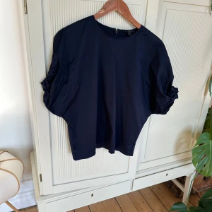 Mörkblå blus, Cos - Sparsamt använd skräddad blus från Cos. Rynk i ärmslut. Ger en sofistikerad look. 