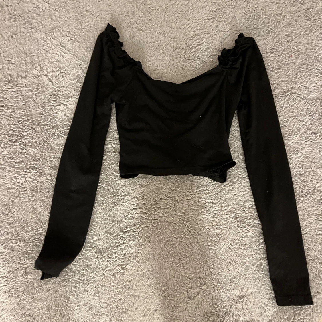 En svart långärmad tröja med design fram till. - 90