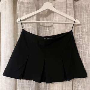 Svart, kort kjol från zara med inbyggda shorts under. Storlek XS. Aldrig använd då den var lågmidjad på mig, vilket inte var tanken när jag köpte den😄Använd gärna ”köp nu”-funktionen🥰