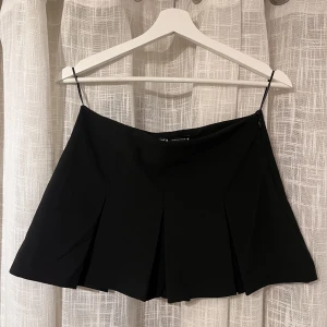 Kjol zara - Svart, kort kjol från zara med inbyggda shorts under. Storlek XS. Aldrig använd då den var lågmidjad på mig, vilket inte var tanken när jag köpte den😄Använd gärna ”köp nu”-funktionen🥰