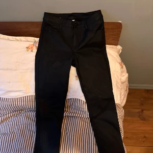 Coated Jeans Low/Mid waisted - Jeans med aningen glansig yta. Kallad coated känns typ vaxade och ger lite av en läder look.  Skitsnygga och tuffa i min mening. Toppen till fest. Skick som nya pga fel storlek för mig. Är M men skulle även passa S
