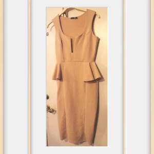 Tjusig klänning  - Fin Krämfärgad klänning.. Sitter en "metallgrej" isytt i tyget vid urringningen. Se sista bild! Märkt strl: Eur 40 mer som 38. 96% polyester 4% Elastan. Endast provad,tvättad 1 gång. 