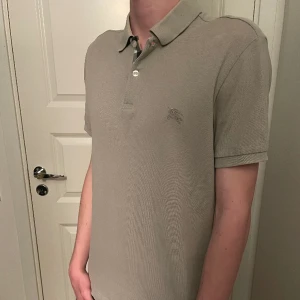 Burberry piké  - Säljer en väldigt snygg Burberry piké som är i väldigt bra skick! Storlek S!  Färgen är grå/beige! Hör gärna av dig om du har frågor!