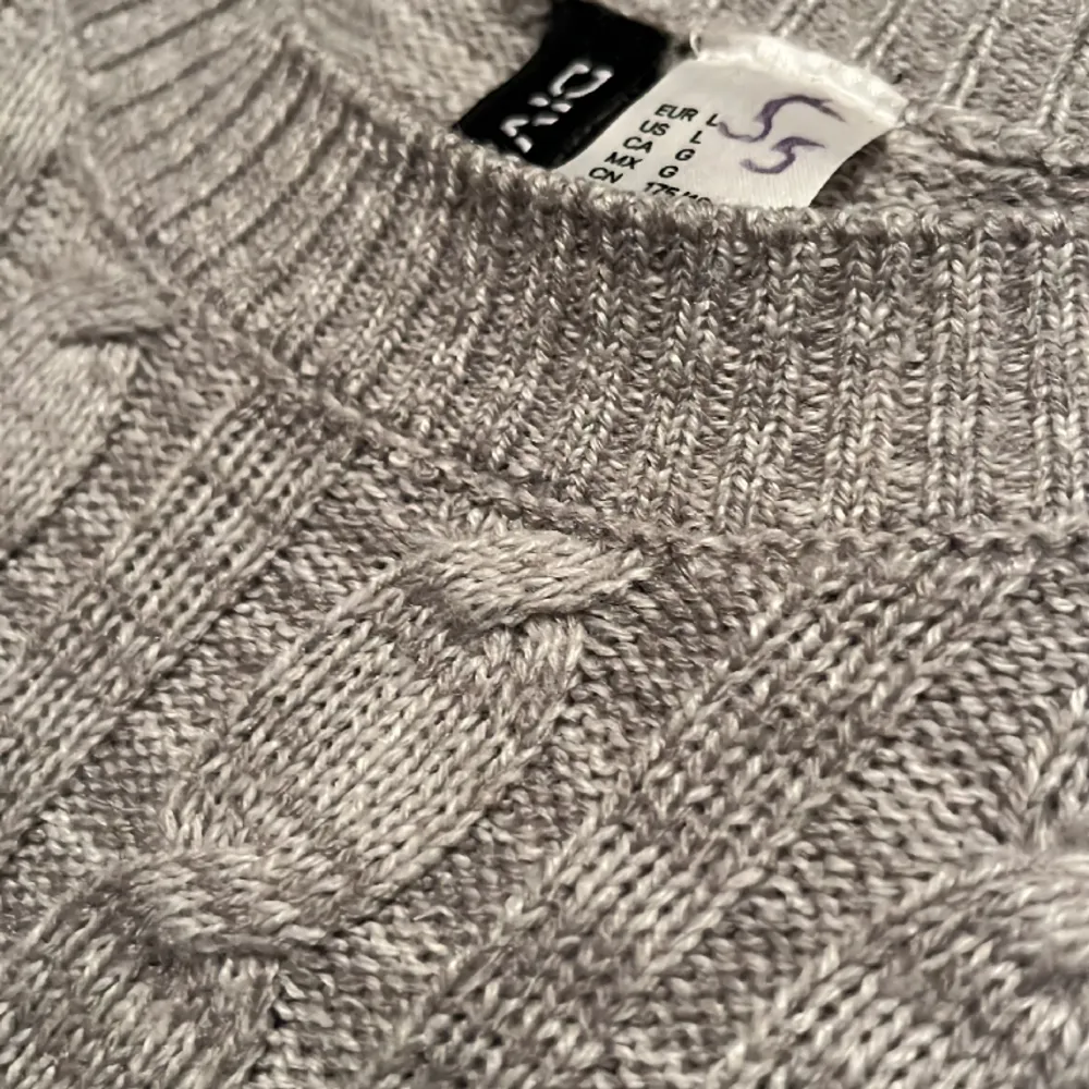 Fin grå långärmad tröja med ett typ flätat mönster på framsidan🩶 Bra skick! Den är i storlek L men man kan även ha den som lite oversized i S!! Det står S på lappen i tröjan men det syns inte när man har på den🩶🩶. Tröjor & Koftor.