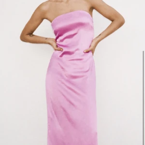 Rosa klänning - Jättefin rosa bandeau klänning i glansigt tyg. Färgen skiftar lite i olika ljus💕🎀🌸Klänningen sitter som på bilderna för mig som är 163 cm. Aldrig använd🤍 Skriv för fler bilder o mått🪩