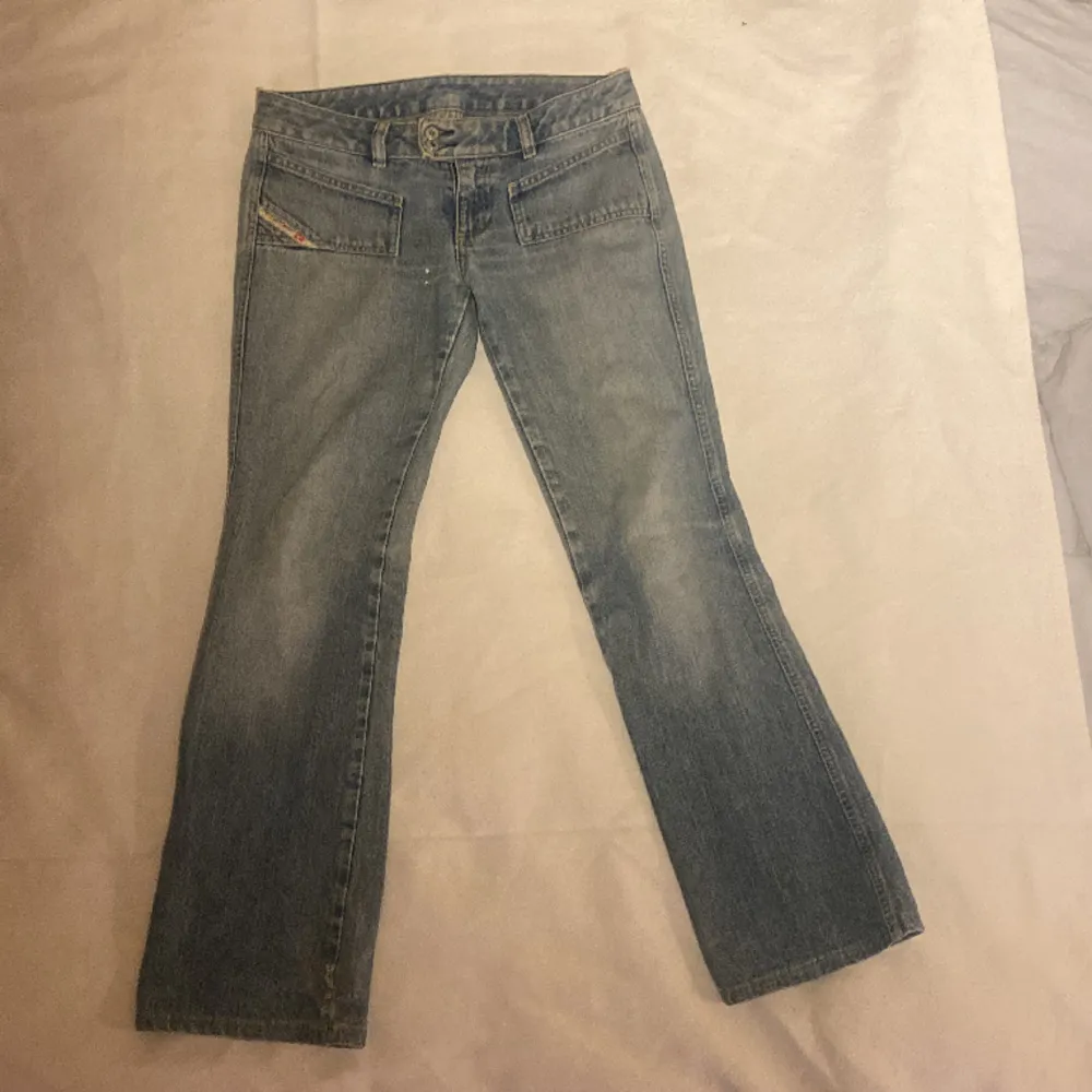 Säljer ett par lågmidjade diseljeans. Jeansen är köpte secondhand men är i bra skick. Ganska korta i längden så passa någon som är under 170. På sista bilden kan du se tydligare vilken färg de är på jeansen💕. Jeans & Byxor.