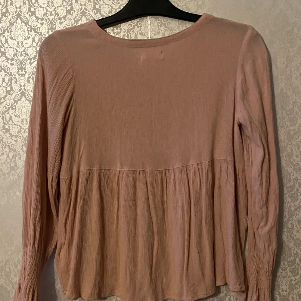 A pink vintage blouse pre loved and use excellent! In a size XS, but can fit a size S since it’s very stretchy. It looks like new and has no noticeable flaws   . Blusar.