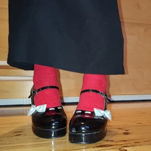 Svarta lackerade Demonia Mary Janes med rosetter<3 - Sjukt söta Mary Janes från Demonia i svart lack. Begagnade men knappt använda. ✩Främre sulan är 2 cm och klacken är ca 4,5 cm. ✩Små guldiga spännen och rosavita rosetter ✩PM för mer info!✩