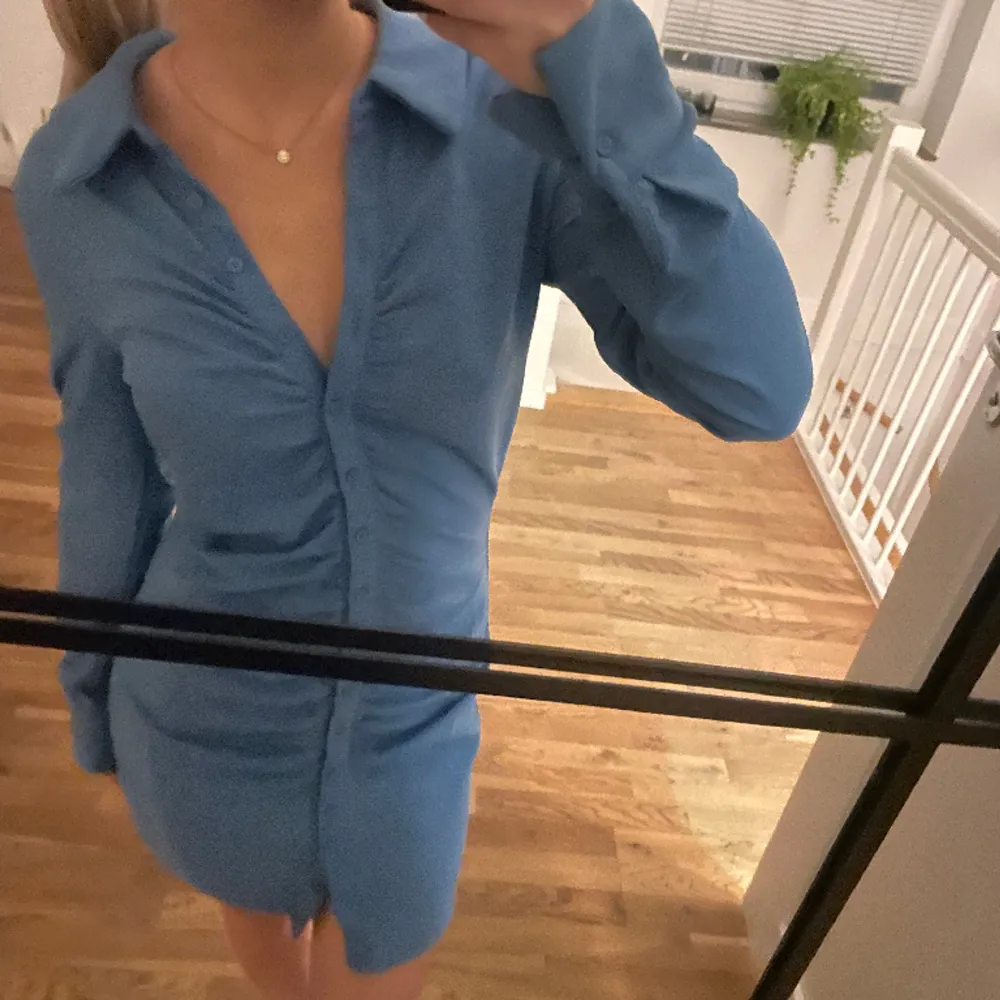 Fin blå klänning med knappar från bikbok. Knappt använd därav fint skick! Jag är 159 cm lång! Köparen står för frakten🙏🏽💕. Klänningar.