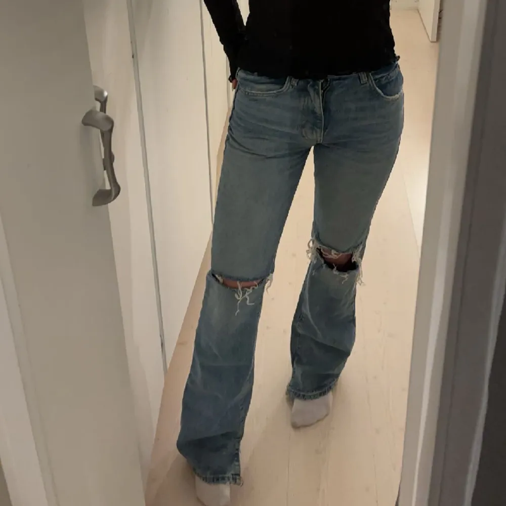 Säljer dessa jätte fina Zara Jean med hål på knäna, dem är mid waist med utsvängda ben. Jeansen har två slits längst ner. Det ser ut som att dem är trasiga men de är så modellen ser ut. Ny pris är 400. Pris förslag!! 💘hör gärna av dig vid frågor!💘. Jeans & Byxor.