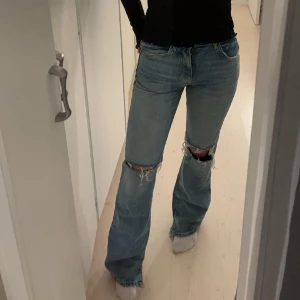 Zara jeans💘🍸 - Säljer dessa jätte fina Zara Jean med hål på knäna, dem är mid waist med utsvängda ben. Jeansen har två slits längst ner. Det ser ut som att dem är trasiga men de är så modellen ser ut. Ny pris är 400. Pris förslag!! 💘hör gärna av dig vid frågor!💘