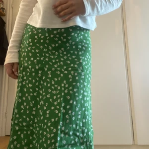 Grön långkjol - En grön långkjol med vita blommor på från Hm. Storlek xs❣️