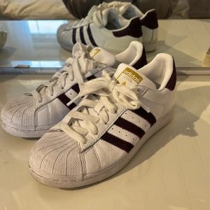 Sneakers  - Sneakers från adidas med lila detaljer, använda fåtal gånger men fortfarande i mycket gott skick. Storlek 38