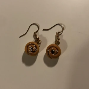 Kanelbulle örhängen  - Säljer dessa söta örhängen som föreställer kanelbullar då jag inte använder dem! Vet ej vilket material men har ej reagerat på dem❤️