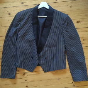 En kortare svart och vitrandig kavaj - En vintage kavaj från Frankrike i svart och vitrandigt mönster som slutar ovanför svanskotan och höfterna.