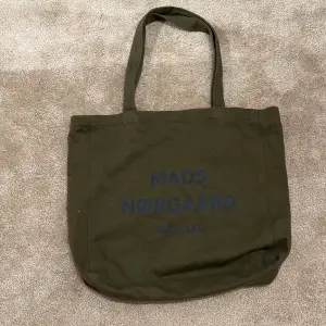 Säljer denna tygväska från Mads Nørgaard i militärgrön färg. Väskan är i bra skick och har sällan kommit till användning.