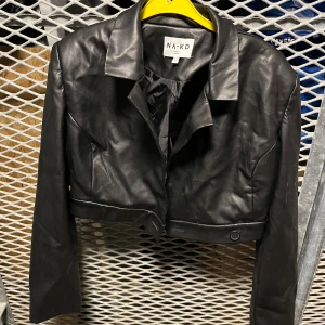 Croppad skinnjacka från NAKD - Skinnjacka, tunn och croppad. Perfekt nu när kyliga sommarkvällar närmar sig. 