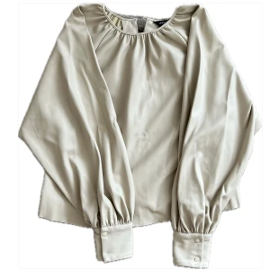 Beige konstläder blus - Fin blus i konstläder material. Mjuk på insidan med knapp bakom nacken. Storlek S.