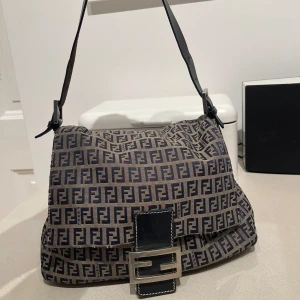 Fendi väska - Säljer min älskade Fendi väska som jag köpt på The Vintage Bar. Den är i fint använt skick och det är bara att skriva så skickar jag fler bilder och äkhetsbevis/kvitto. Modell: Navy Fendi Canvas Baugette. Pris 4500 kronor eller bud. 