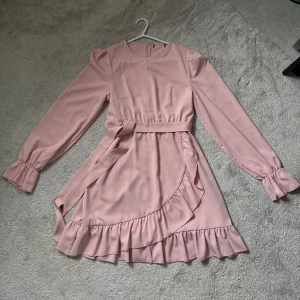 Rosa klänning  - Knä längd  Volanger + fuff armar  