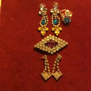 Vintage strassmycken - Två par strassörhängen för hål, en gnistrande strassbrosch, en ring med färgad sten, reglerbar skena. 