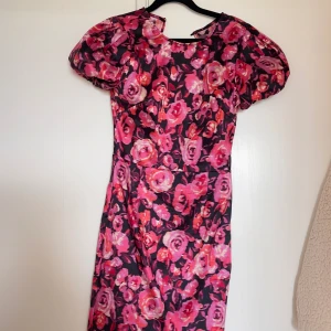 Festklänning - Säljer denna underbara klänning med prislapp på då den tyvärr inte kommit till användning. Fin öppen rygg och bra support i tyget så BH behövs ej. 