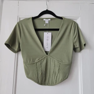Topp - Grön topp från new yorker. Prislapp kvar, aldrig använd. Nypris 95 kr. Har även en likadan i grått som jag även säljer (se annons). 