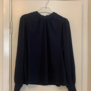 Marinblå blus - Marinblå blus i stretchigt följdamt material. Sparsamt använd. I bra begagnat skick. Hund finns i hemet. 