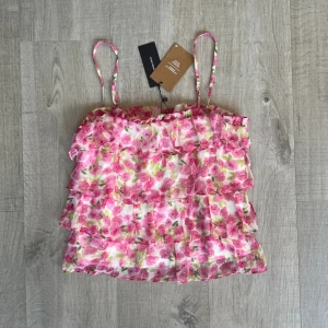 Blommig topp  - Säljer denna fina blommiga topp köpt från vero Moda. Stl S. Justerbara band. Aldrig använd 