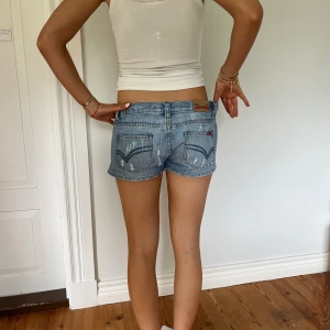 Lågmidjade shorts  - Lågmidjade vintage shorts  Jag på bilden är 170cm.  Midjemåttet: 41cm (rätt över )  Längd: 23cm Inga defekter 💕 använd dig utav köp nu🫶