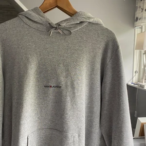 Saint Laurent Hoodie - Tja, säljer min feta YSL hoodie! Perfekt nu till sommaren! Nypris kan ses på bild 3! Tveka inte att höra av vid funderingar eller eventuellt fler bilder