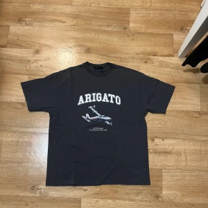 Axel arigato T shirt  - Säljer denna mörkgråa limited edition Axel Arigato t shirt, storlek XS men passar upp till M beroende på hur du vill att den ska sitta, inte använd så mycket så väldigt fint skick, nypris runt 1000, kan mötas upp.