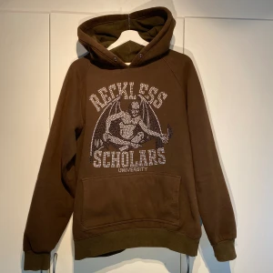 Reckless Scholars Rhinestone Hoodie - Hej, säljer en Rhinestone hoodie från Reckless Scholars i brun färg. Använd men fortfarande i dugligt skick. Slutsåld & Exklusiv och endast släppt i begränsat antal. Storlek L. Enormt gosig och bekväm. Tungt och kvalitativt material. Hörs i DM! 