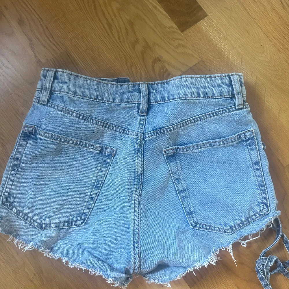 Jätte snygga och coola jeansshorts med detaljer på sidorna.  De är högmidjade men själv brukar jag vika ner de som på bilden och då sitter de snyggt på och blir lågmidjade 💓  Storleken är 36 och de har nästan aldrig använts 💓. Shorts.